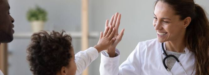 Ärztin und Kind geben sich High-five