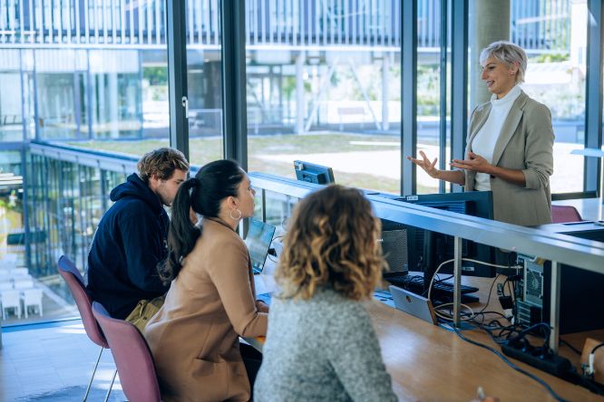 Studierende unterhalten sich im Lernraum der Bibliothek
