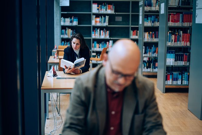 Studierende sitzen bei den Leseplätzen in Bibliothek im Trakt C Erdgeschoss