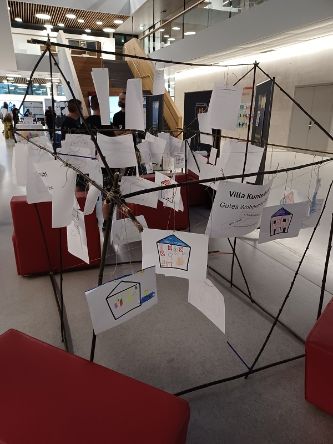 Zeichnungen, die auf Stangenkonstruktion von Messestand montiert sind