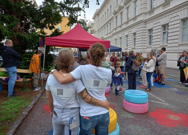 Rückansicht von 2 Damen mit weißem T-Shirt mit QR-Code darauf