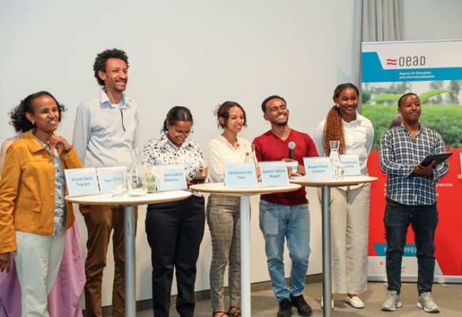 Projektpartner stehen bei Stehtischen und lachen