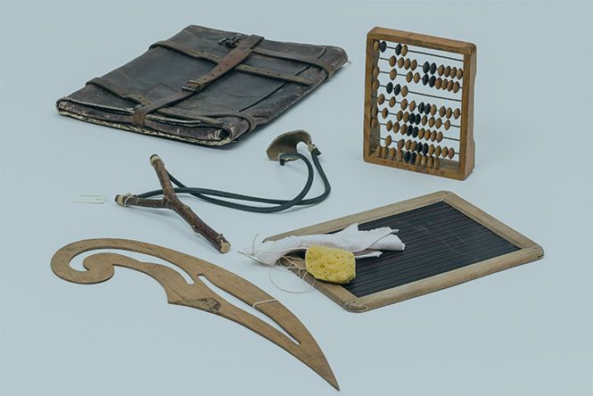 Schulische Gebrauchsgegenstände (Steinschleuder, Rechenschieber, kleine Tafel und mehr) aus der Lehrmittelsammlung der Schule Michelstetten