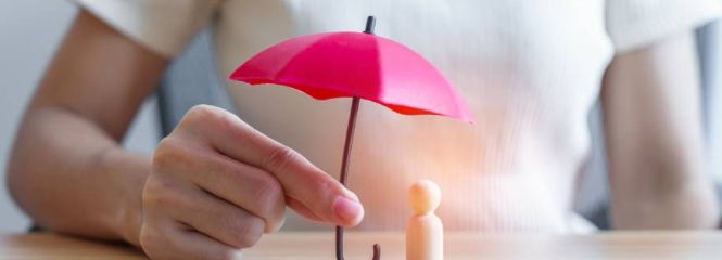 Imagebild ein rosa Schirm unter dem eine hölzerne Spielfigur steht
