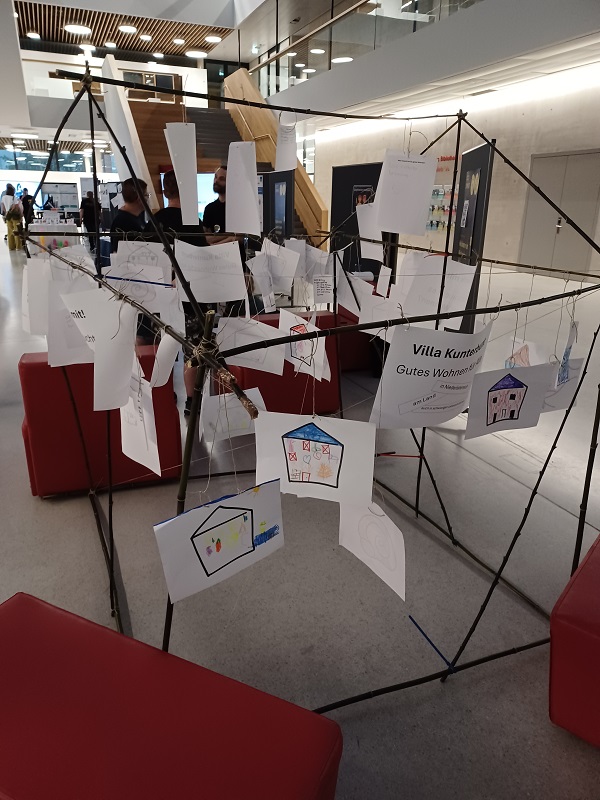 Zeichnungen, die auf Stangenkonstruktion von Messestand montiert sind