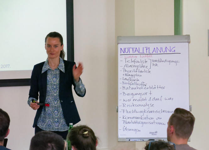 Anna Kaiser vor Flipchart bei Vortrag