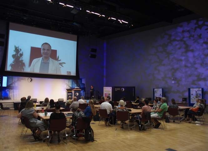 Dr. Oppl spricht online zum Publikum.